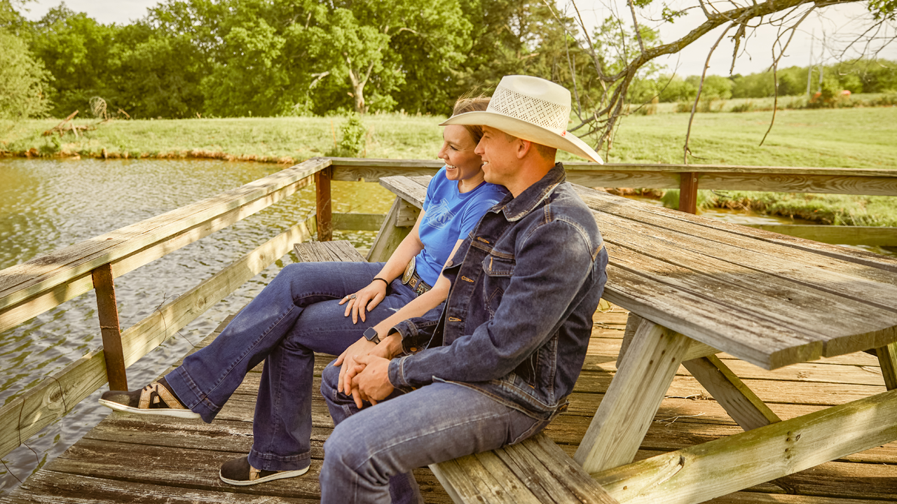 Cody and women sitting on picnic bench looking out over water